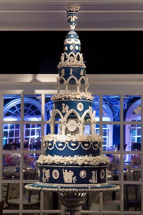 five-tiered-wedding-cake-is-decorated-in-blue-and-white-with-columns-flowers-and-white-fondant-vignettes